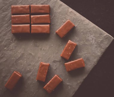 Bir taş masa üstü, flatlay - tatlılar, şekerlemeler ve glutensiz organik gıda kavramı üzerinde tatlı İsviçre çikolata şekerleme. Tek ihtiyacınız olan çikolata