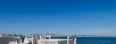 Beyaz Restoran tablolar sahilde yaz - seyahat, tatil ve yaz konsepti. Deniz manzaralı mükemmel bir öğle yemeği