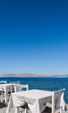 Beyaz Restoran tablolar sahilde yaz - seyahat, tatil ve yaz konsepti. Deniz manzaralı mükemmel bir öğle yemeği