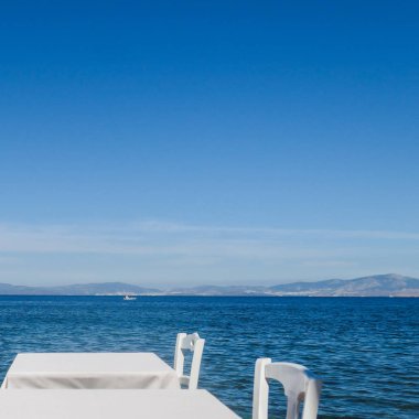 Beyaz Restoran tablolar sahilde yaz - seyahat, tatil ve yaz konsepti. Deniz manzaralı mükemmel bir öğle yemeği