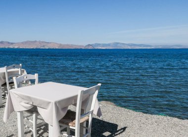 Beyaz Restoran tablolar sahilde yaz - seyahat, tatil ve yaz konsepti. Deniz manzaralı mükemmel bir öğle yemeği