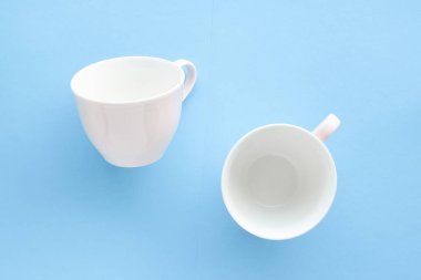 Boş Kupası ve fincan tabağı üzerinde mavi arka plan, flatlay