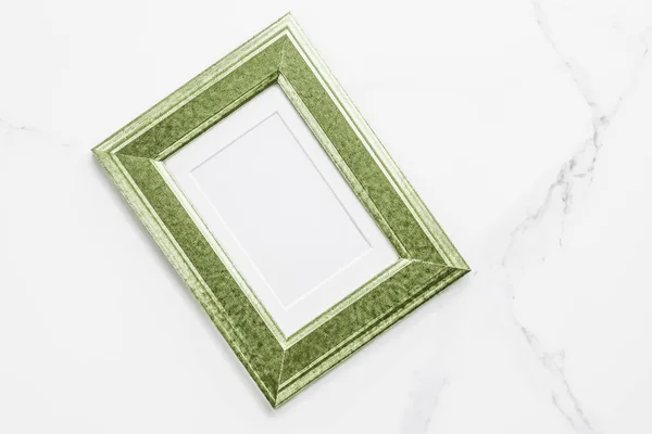 Green photo frame on marble, flatlay — Stock Photo, Image