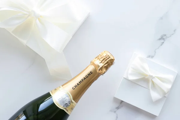 Eine Champagnerflasche und eine Geschenkbox auf Marmor — Stockfoto