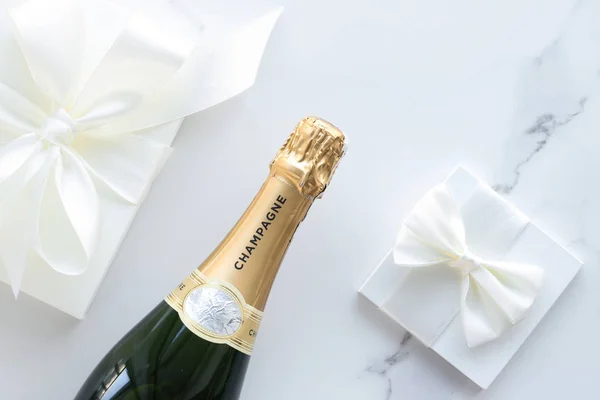 Eine Champagnerflasche und eine Geschenkbox auf Marmor — Stockfoto