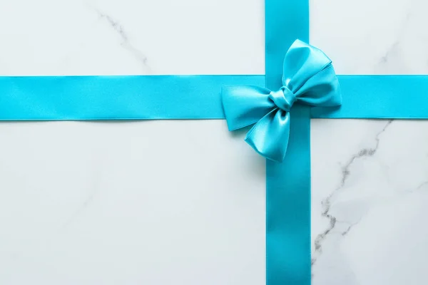 Blue silk ribbon on marble, top view — Stock Photo, Image