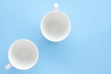 Boş Kupası ve fincan tabağı üzerinde mavi arka plan, flatlay