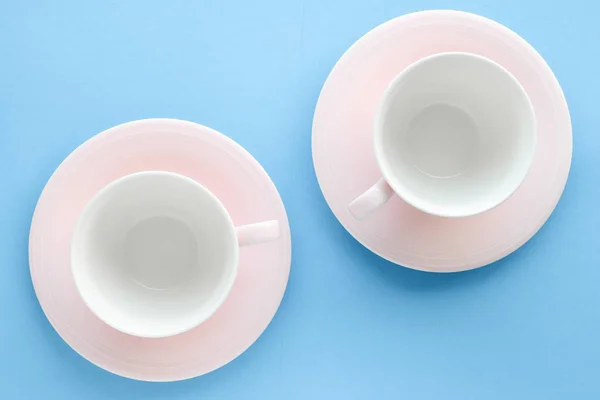 Boş Kupası ve fincan tabağı üzerinde mavi arka plan, flatlay — Stok fotoğraf