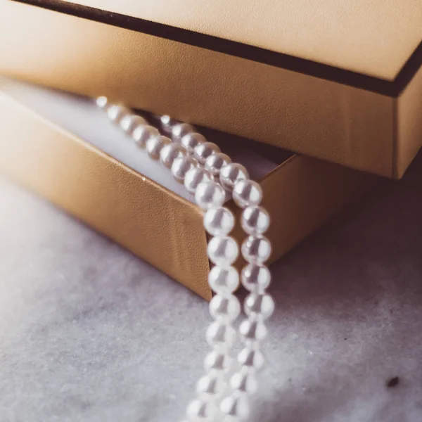 Perlenschmuck in einer goldenen Geschenkschachtel — Stockfoto