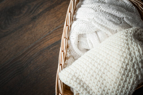 Knitted winter clothes in a basket
