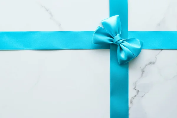 Blue silk ribbon on marble, top view — Stock Photo, Image