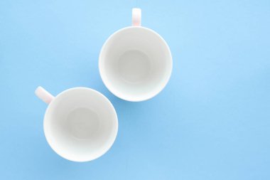 Boş Kupası ve fincan tabağı üzerinde mavi arka plan, flatlay