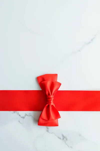 Red silk ribbon on marble, top view