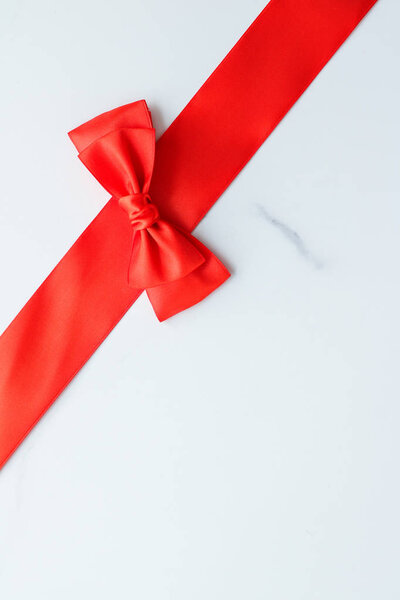 Red silk ribbon on marble, top view