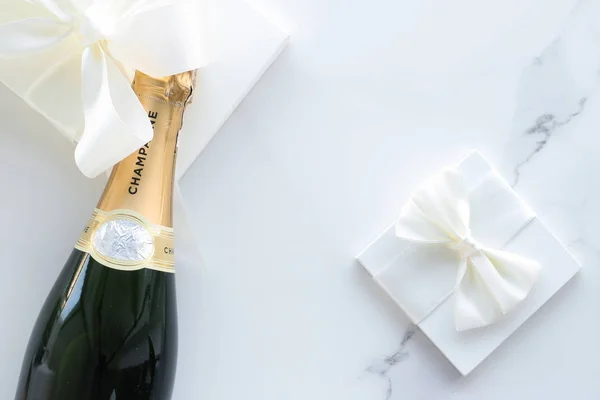 Eine Champagnerflasche und eine Geschenkbox auf Marmor — Stockfoto