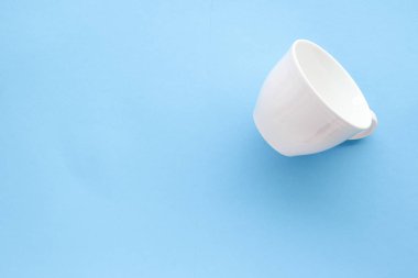 Boş Kupası ve fincan tabağı üzerinde mavi arka plan, flatlay