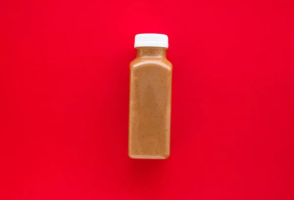 Бутылка шоколадного бананового коктейля на красном, плоском — стоковое фото
