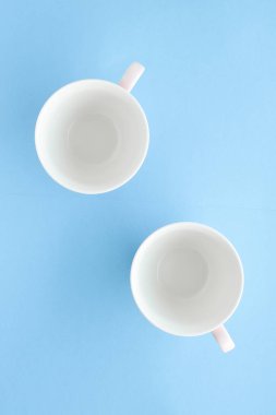 Boş Kupası ve fincan tabağı üzerinde mavi arka plan, flatlay