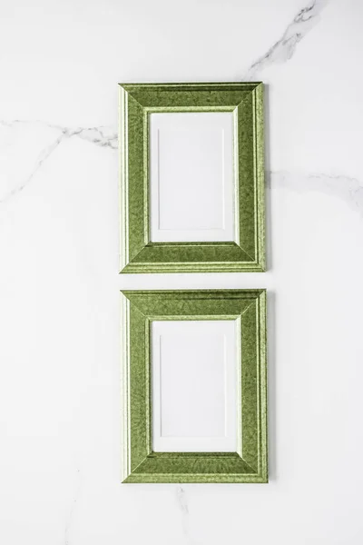 Green photo frame on marble, flatlay — Stock Photo, Image