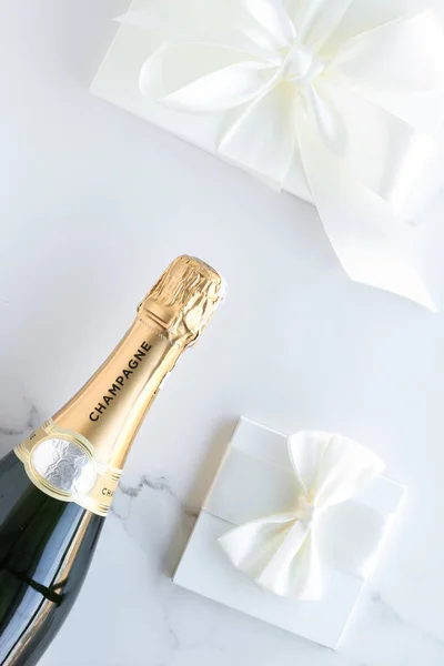 Eine Champagnerflasche und eine Geschenkbox auf Marmor — Stockfoto