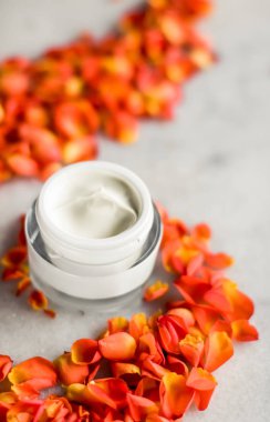 Mermer üzerinde güzellik yüz nemlendirici krem ve çiçek yaprakları, LuXu