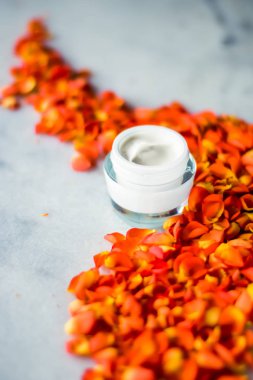 Mermer üzerinde güzellik yüz nemlendirici krem ve çiçek yaprakları, LuXu