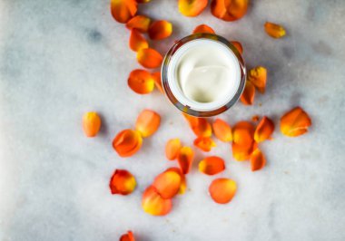 Mermer üzerinde güzellik yüz nemlendirici krem ve çiçek yaprakları, LuXu