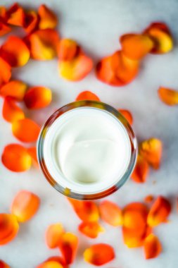 Mermer üzerinde güzellik yüz nemlendirici krem ve çiçek yaprakları, LuXu