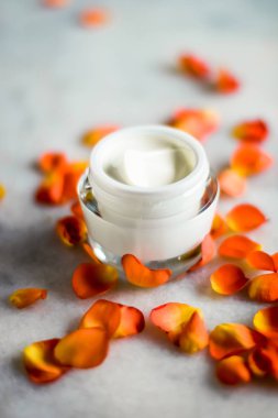 Mermer üzerinde güzellik yüz nemlendirici krem ve çiçek yaprakları, LuXu