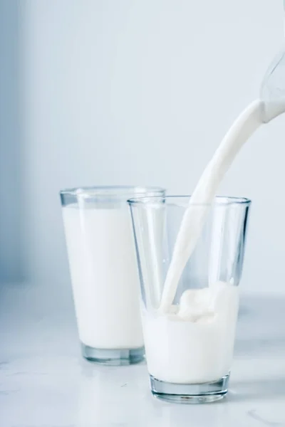 Giornata Mondiale del Latte, versando in vetro sul tavolo di marmo — Foto Stock