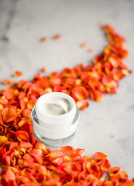 Mermer üzerinde güzellik yüz nemlendirici krem ve çiçek yaprakları, LuXu