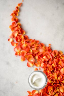 Mermer üzerinde güzellik yüz nemlendirici krem ve çiçek yaprakları, LuXu