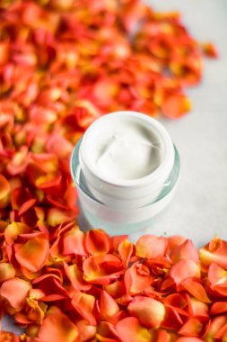 Mermer üzerinde güzellik yüz nemlendirici krem ve çiçek yaprakları, LuXu