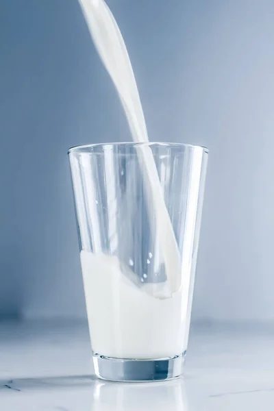 Giornata Mondiale del Latte, versando in vetro sul tavolo di marmo — Foto Stock