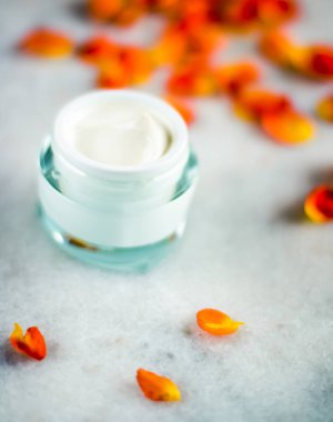 Mermer üzerinde güzellik yüz nemlendirici krem ve çiçek yaprakları, LuXu