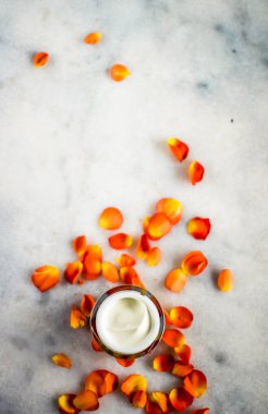 Mermer üzerinde güzellik yüz nemlendirici krem ve çiçek yaprakları, LuXu