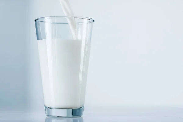 Giornata Mondiale del Latte, versando in vetro sul tavolo di marmo — Foto Stock