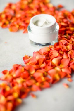 Mermer üzerinde güzellik yüz nemlendirici krem ve çiçek yaprakları, LuXu