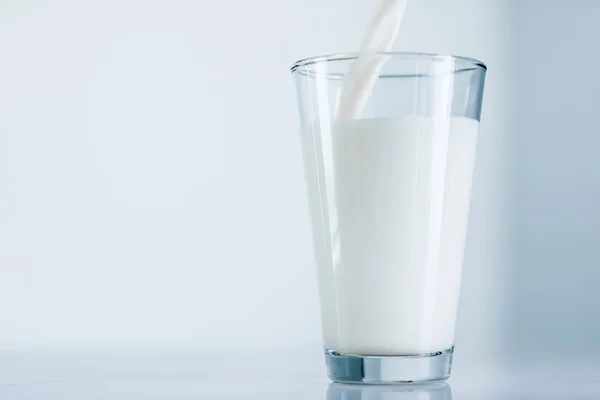 Giornata Mondiale del Latte, versando in vetro sul tavolo di marmo — Foto Stock