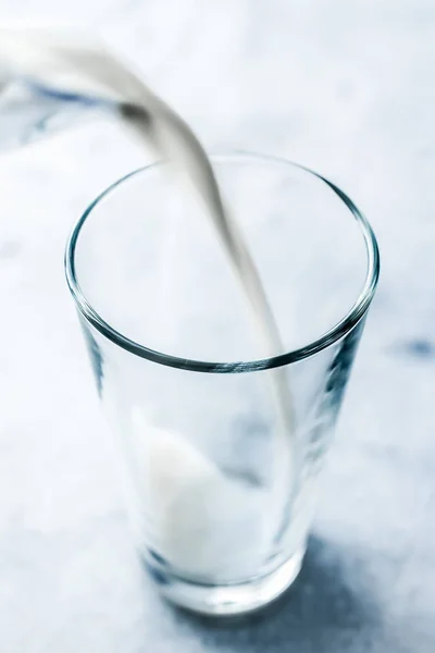 Día Mundial de la Leche, vertiendo en el vidrio sobre la mesa de mármol — Foto de Stock