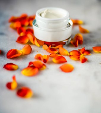 Mermer üzerinde güzellik yüz nemlendirici krem ve çiçek yaprakları, LuXu