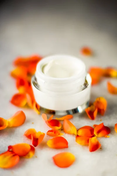 Crema hidratante de la cara de belleza y pétalos de flores en mármol, luxu — Foto de Stock