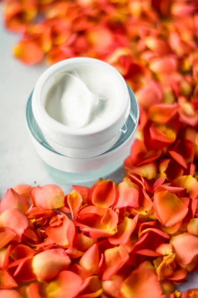 Crema hidratante de la cara de belleza y pétalos de flores en mármol, luxu — Foto de Stock