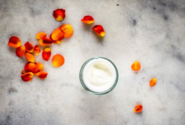 Mermer üzerinde güzellik yüz nemlendirici krem ve çiçek yaprakları, LuXu