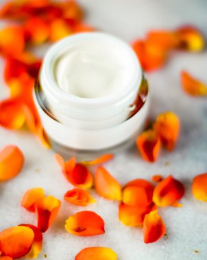 Mermer üzerinde güzellik yüz nemlendirici krem ve çiçek yaprakları, LuXu