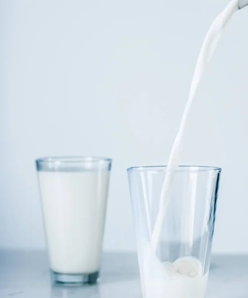 Světový den mléka, nalévání do skla na mramorovém stole — Stock fotografie