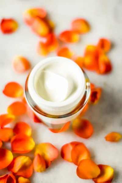 Crema hidratante de la cara de belleza y pétalos de flores en mármol, luxu — Foto de Stock