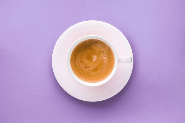 Чашка кофе на фиолетовом фоне, вид сверху плоский — стоковое фото