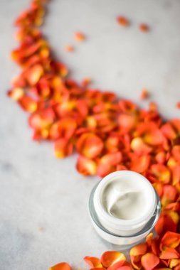 Mermer üzerinde güzellik yüz nemlendirici krem ve çiçek yaprakları, LuXu