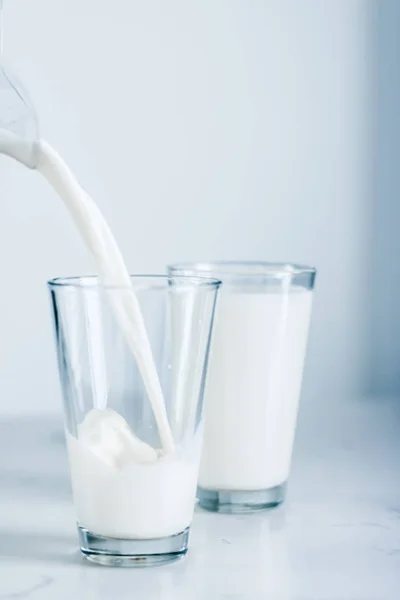 Giornata Mondiale del Latte, versando in vetro sul tavolo di marmo — Foto Stock